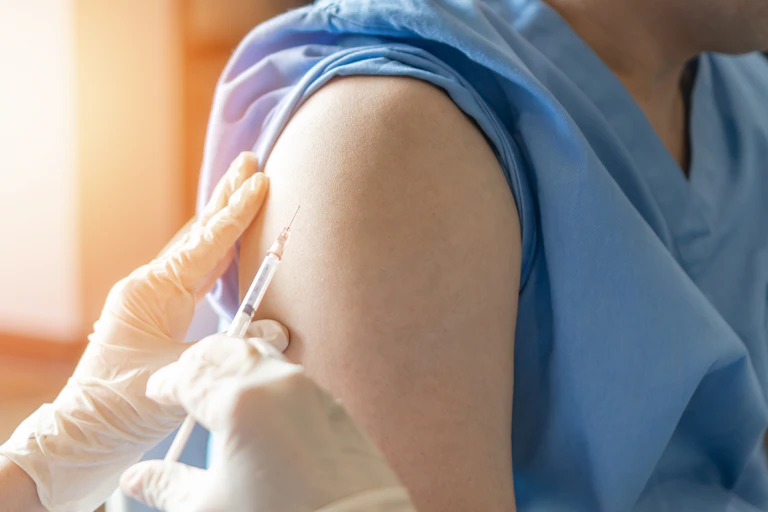 A doctor or nurse is about to give someone a vaccine in their arm.