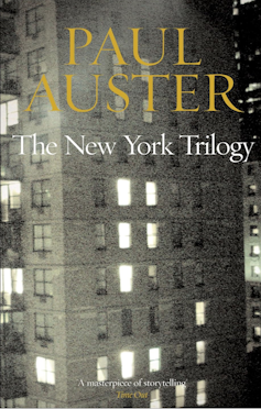 The cover of the novel The New York Trilogy by Paul Auster, showing an apartment building in New York.