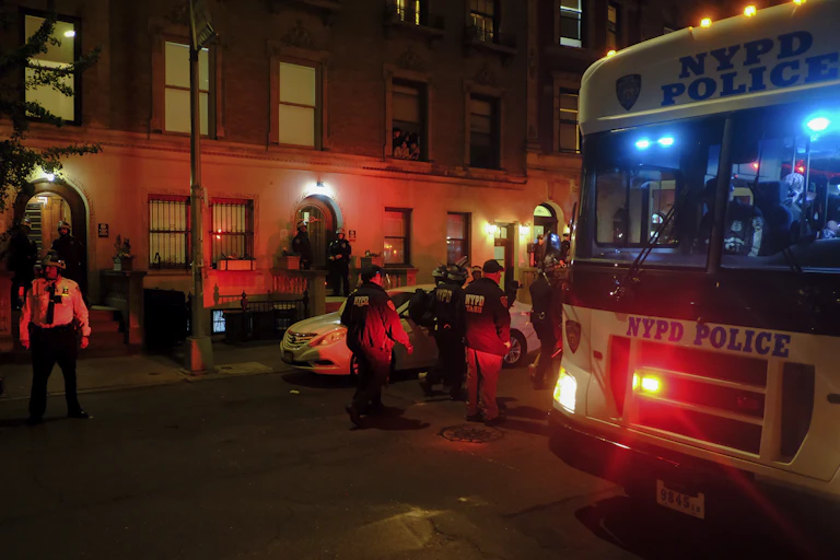 police escort protestors on to a bus marked NYPD POLICE
