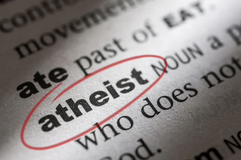 An open dictionary page with the word 'atheist' circled in red ink.