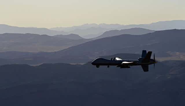 a pilotless aircraft flies above a mountain range