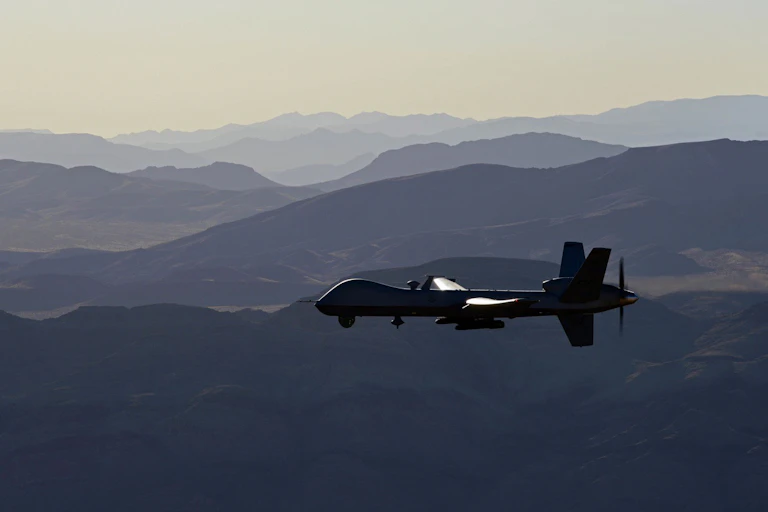a pilotless aircraft flies above a mountain range
