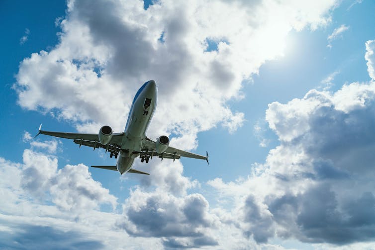 Photo of a passenger jet against a cloudy sky.