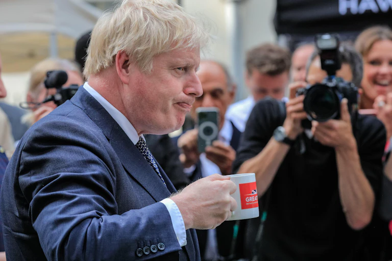 Boris Johnson drinking from a mug.