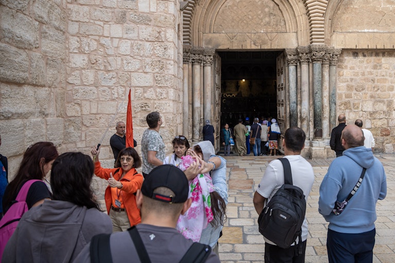 A crowd of tourists entering an old church.
