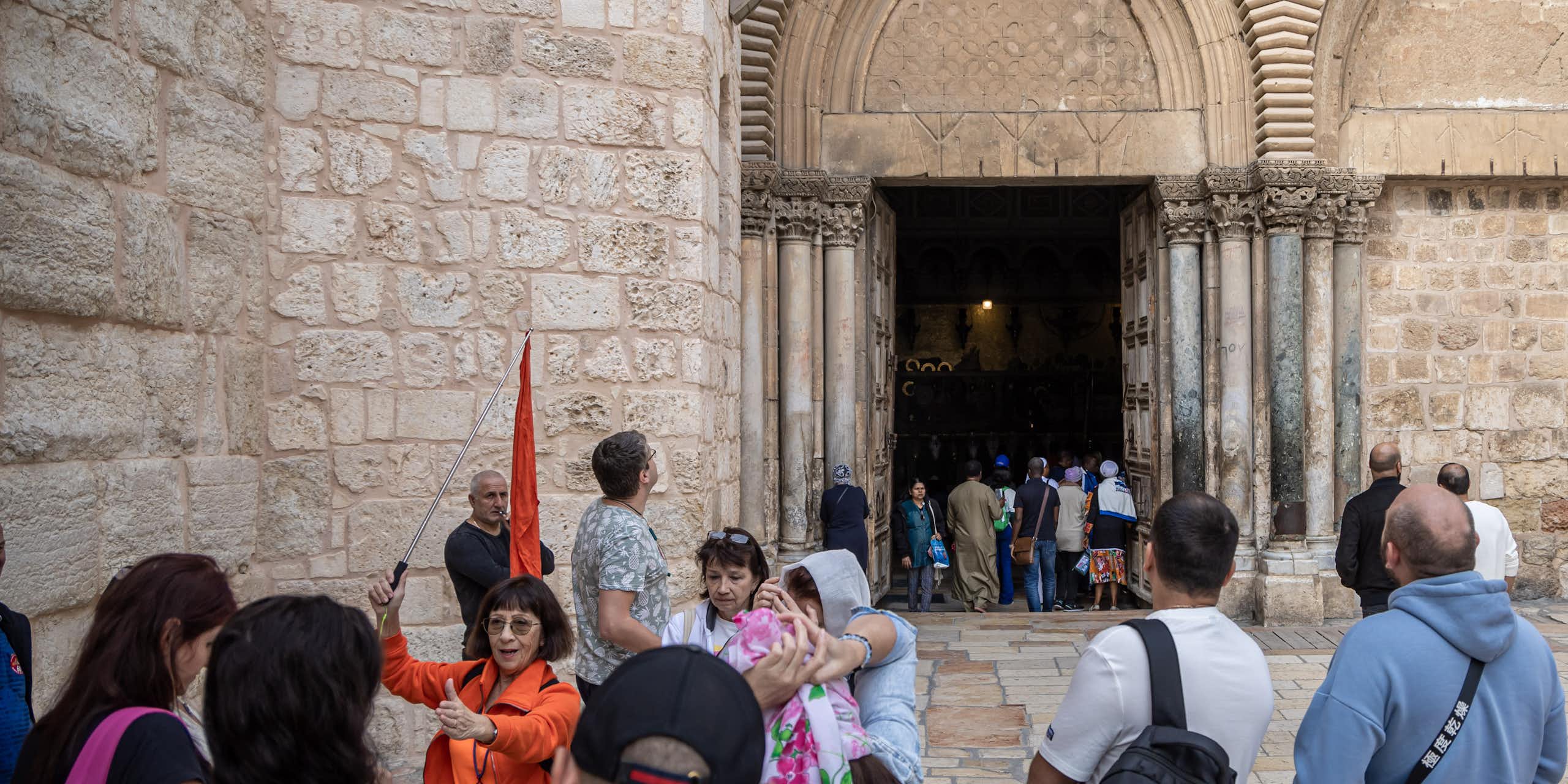 A crowd of tourists entering an old church.