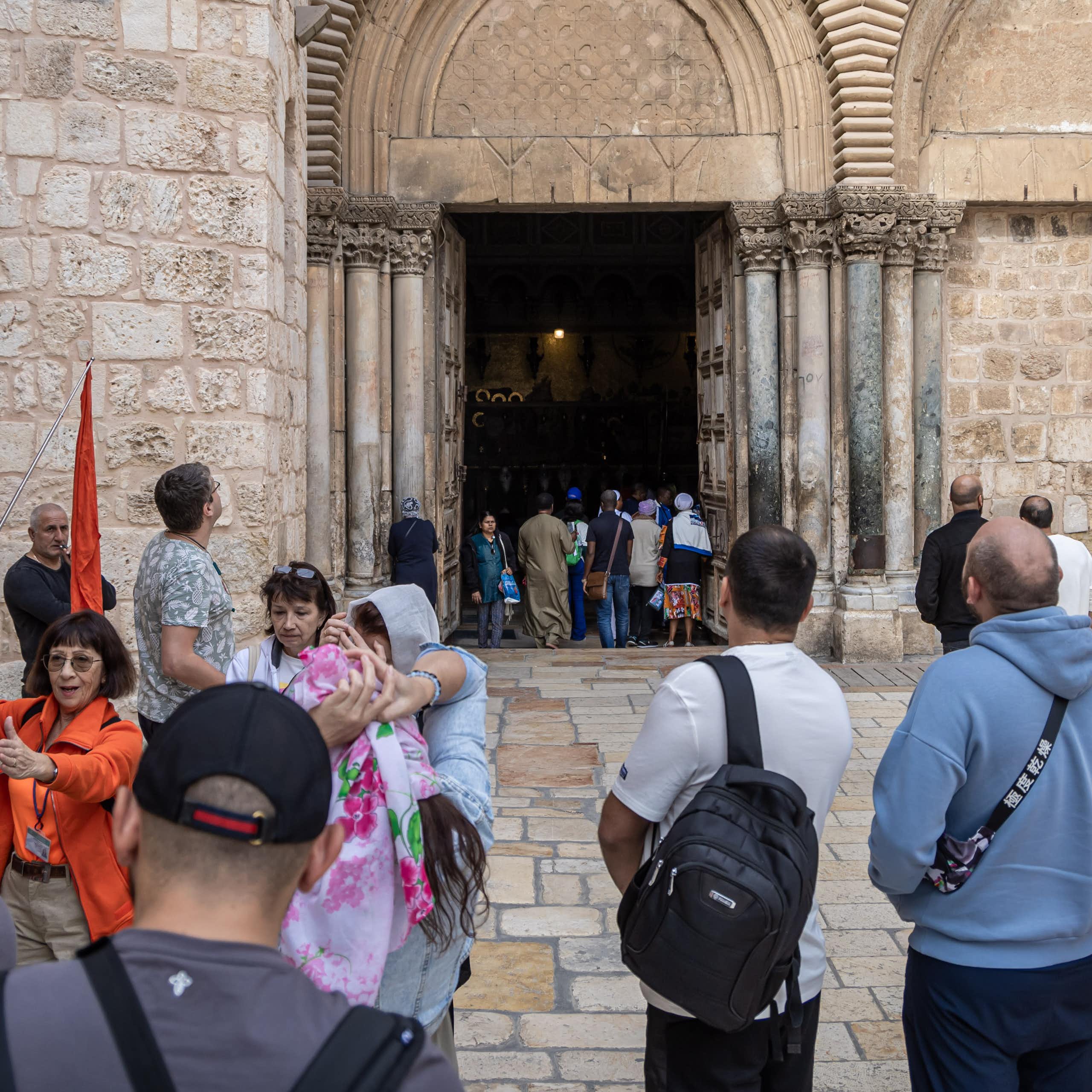 A crowd of tourists entering an old church.