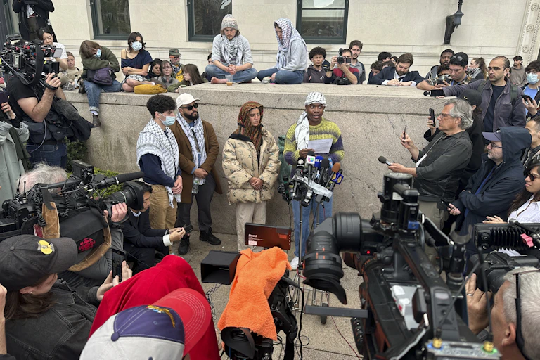 A group of people stand next to microphones.