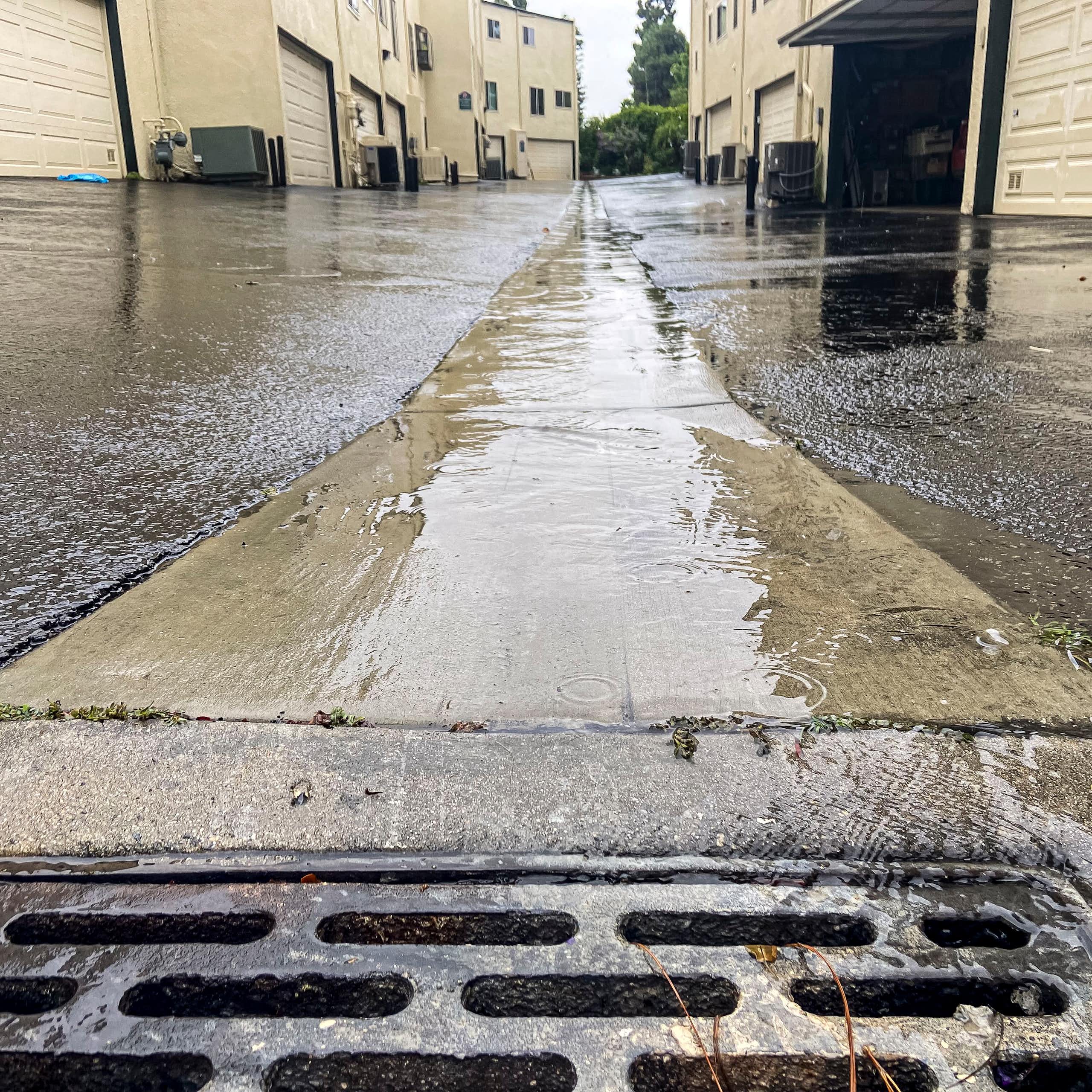 An alley covered with water flowing to a drain