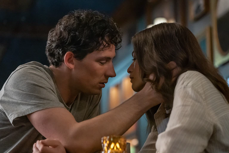 Production image: a man and woman lean in for a kiss