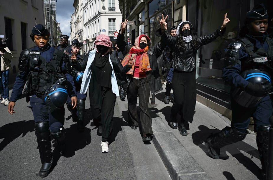 Des manifestants escortés par des gendarmes lors de l'évacuation d'un sit-in pro-Gaza dans le hall d'entrée de Sciences Po Paris, le 3 mai 2024.