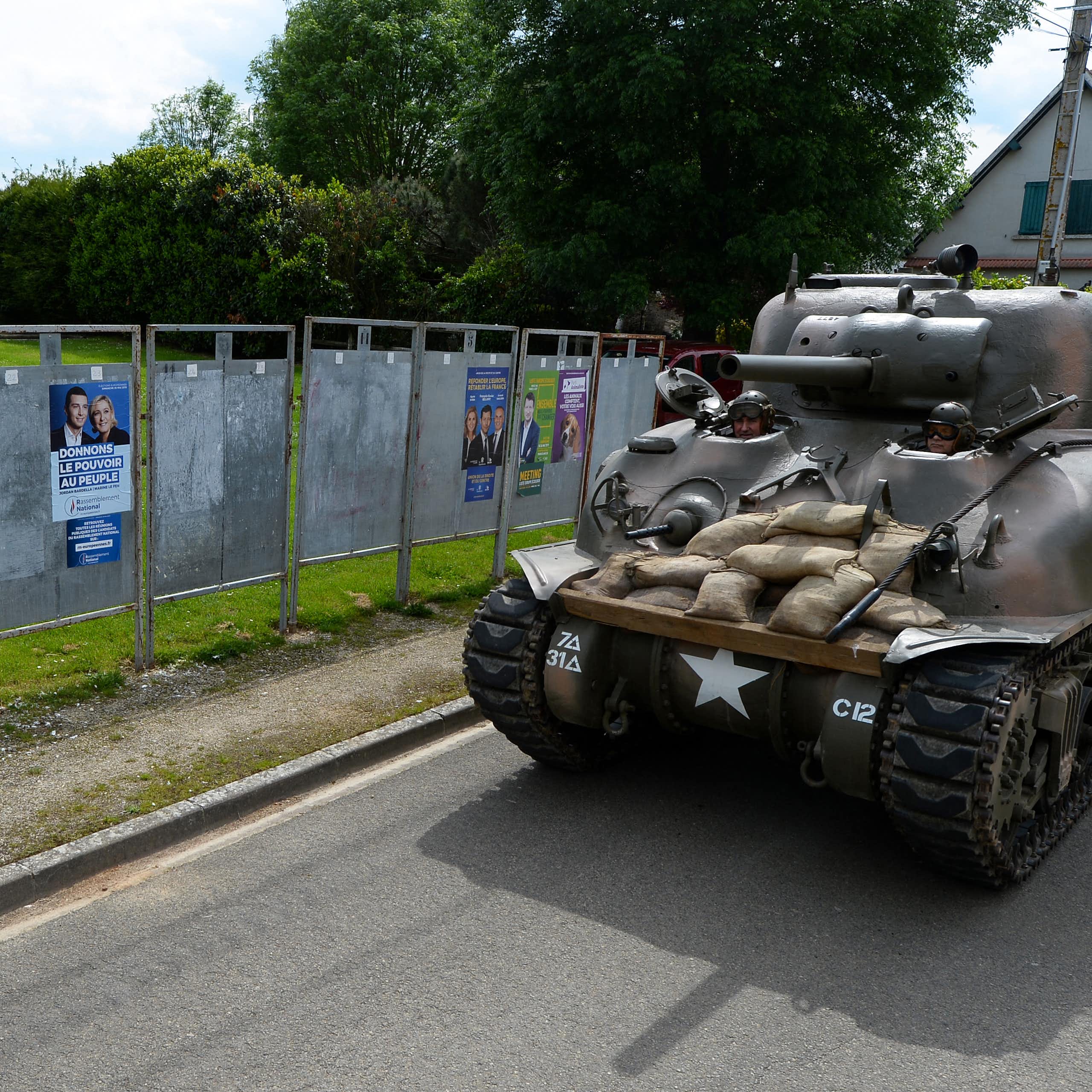 Un collectionneur de chars français (Christian Dours) passe dans l'un de ses engins devant des affiches pour les élections européennes de 2019, près de Chartes.