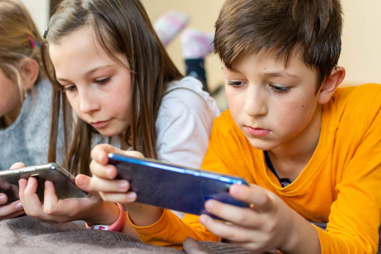 Enfants regardant des écrans de portables