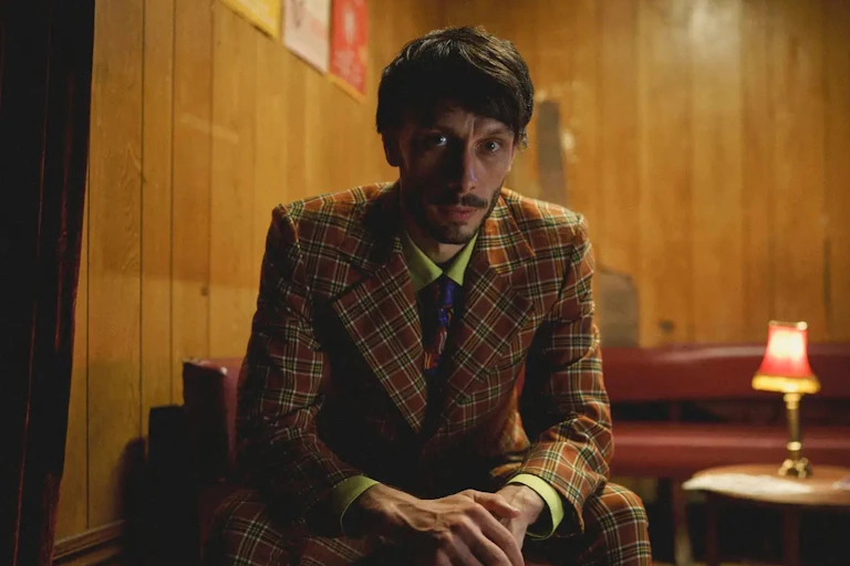 A man in a suit looking straight ahead.