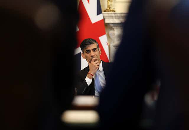 Rishi Sunak sitting in front of a union flag
