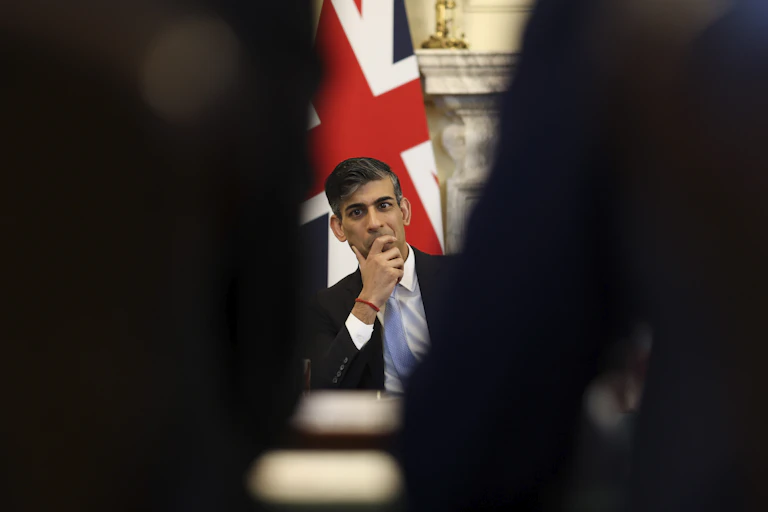 Rishi Sunak sitting in front of a union flag