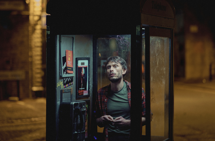 A person in a phonebooth.