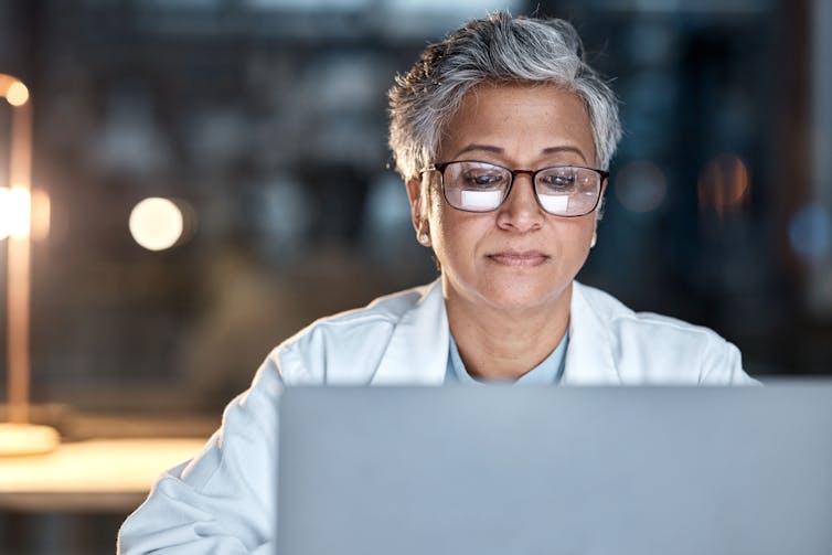 Doctor looks at laptop