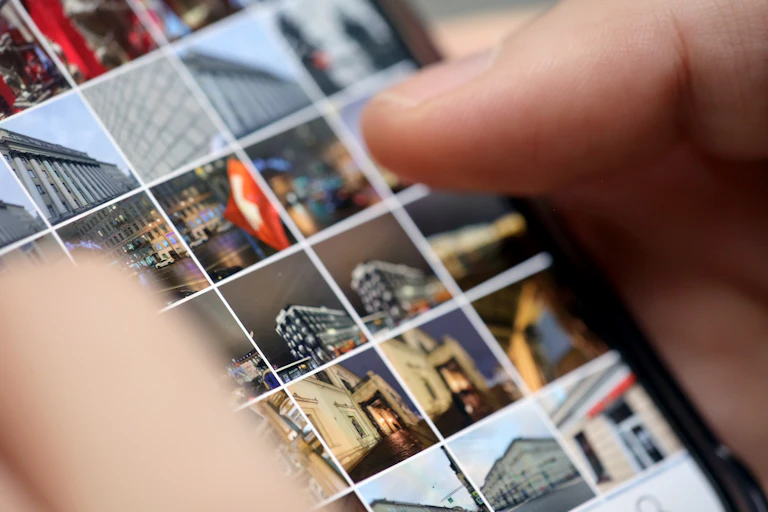A person scrolling through their phone's camera roll.