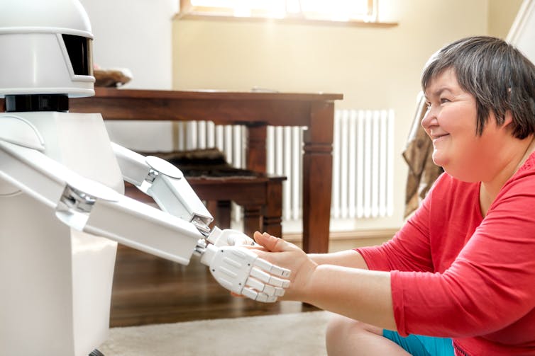 Medical service robot is giving a mentally disabled woman the hand