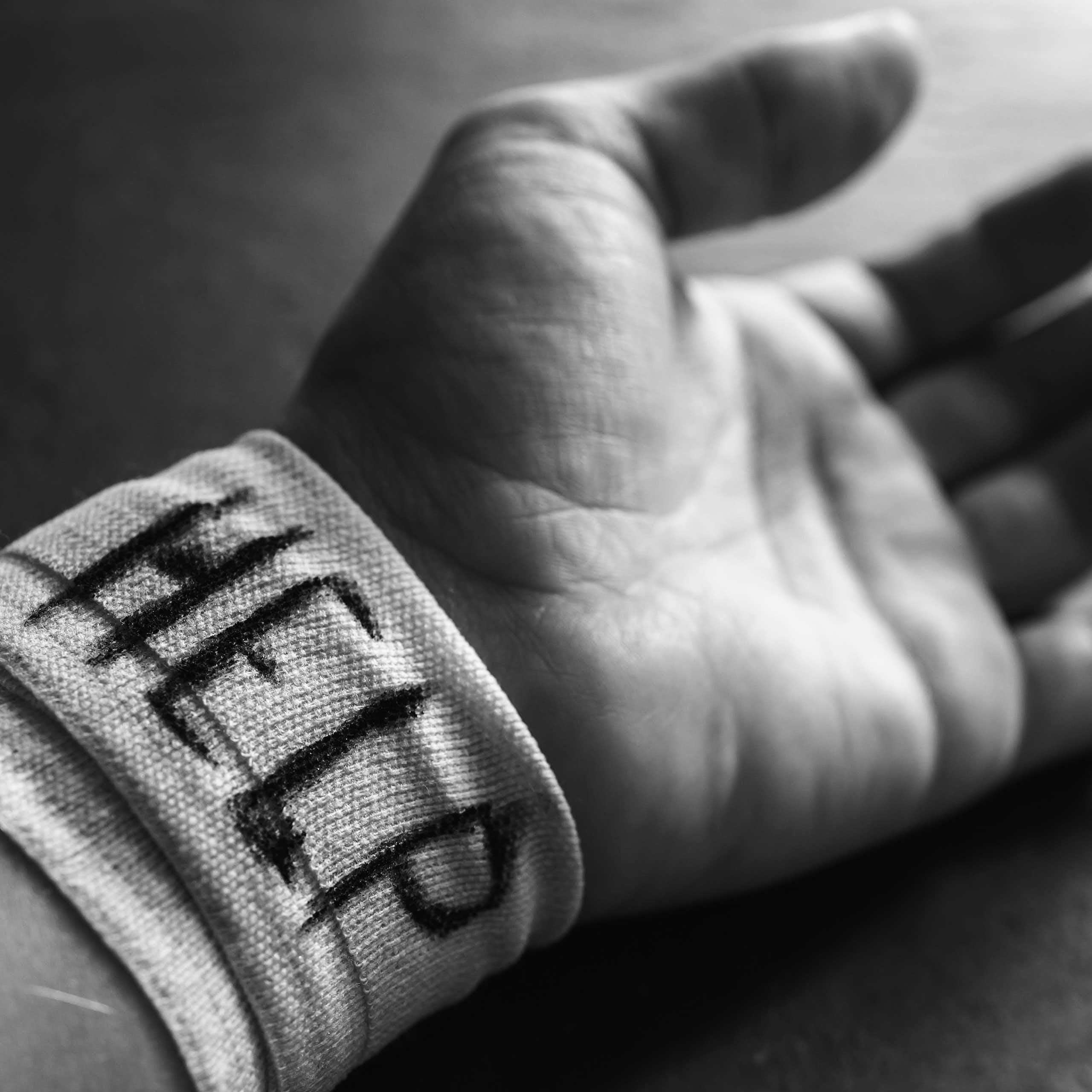 A hand with 'HELP' written on its bandaged wrist
