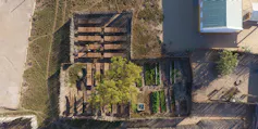 A few rectangular wooden sheds next to each other. Inside, baobab seedlings are growing.