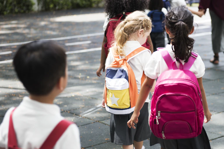 Children in uniforms and rucksacks walking to school