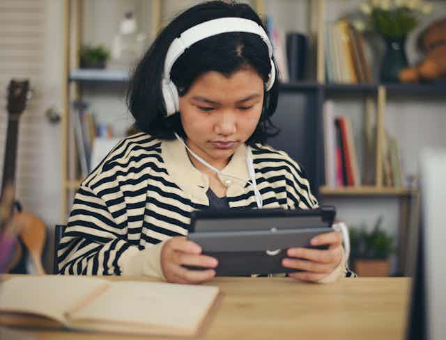 Girl in headphones using tablet