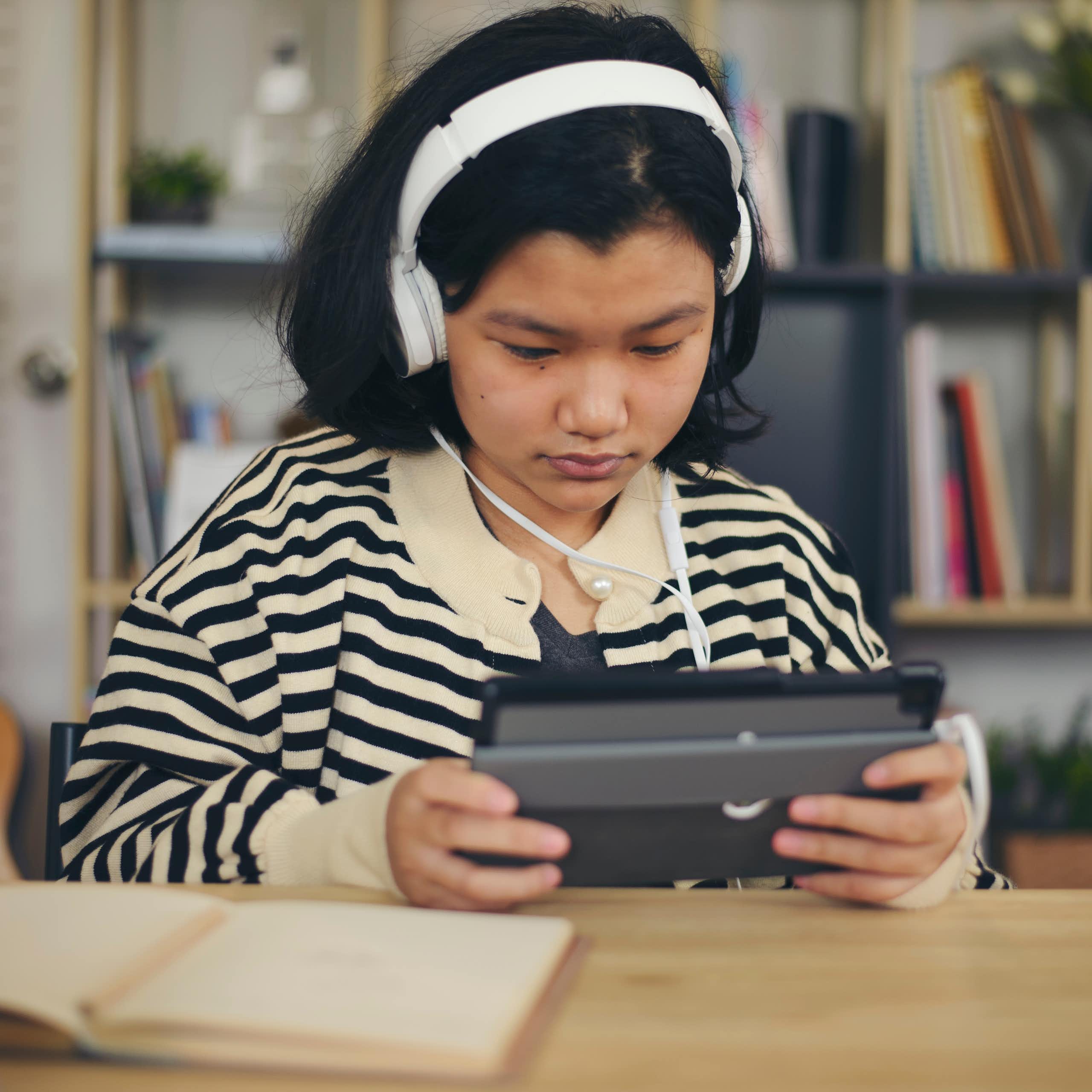 Girl in headphones using tablet