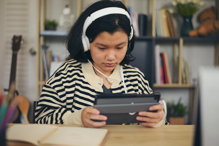 Girl in headphones using tablet