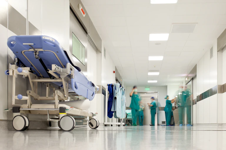 Health-care workers in green scrubs in a hospital corridor