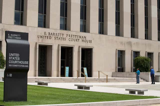 exterior of a concrete building with lettering over three doors
