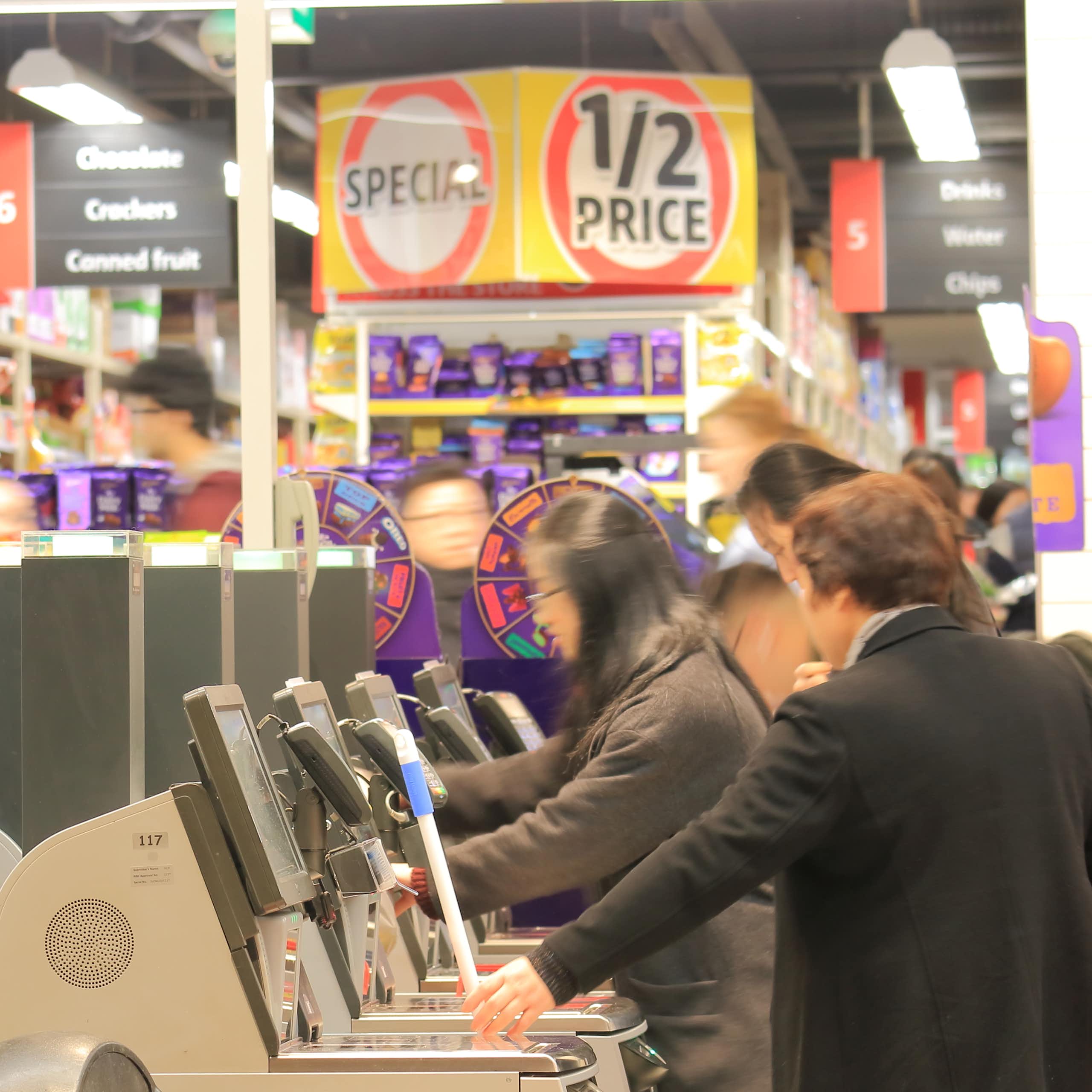 Unidentified people use self check out at a supermarket.