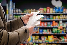 Man in supermarket looking at receipts