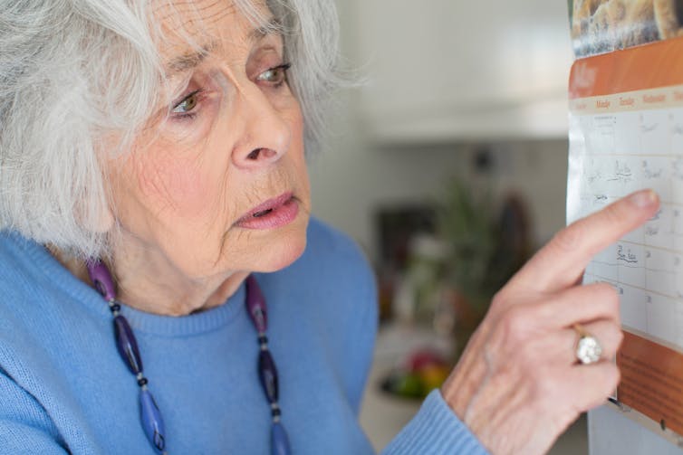 Elderly woman looking at calendar