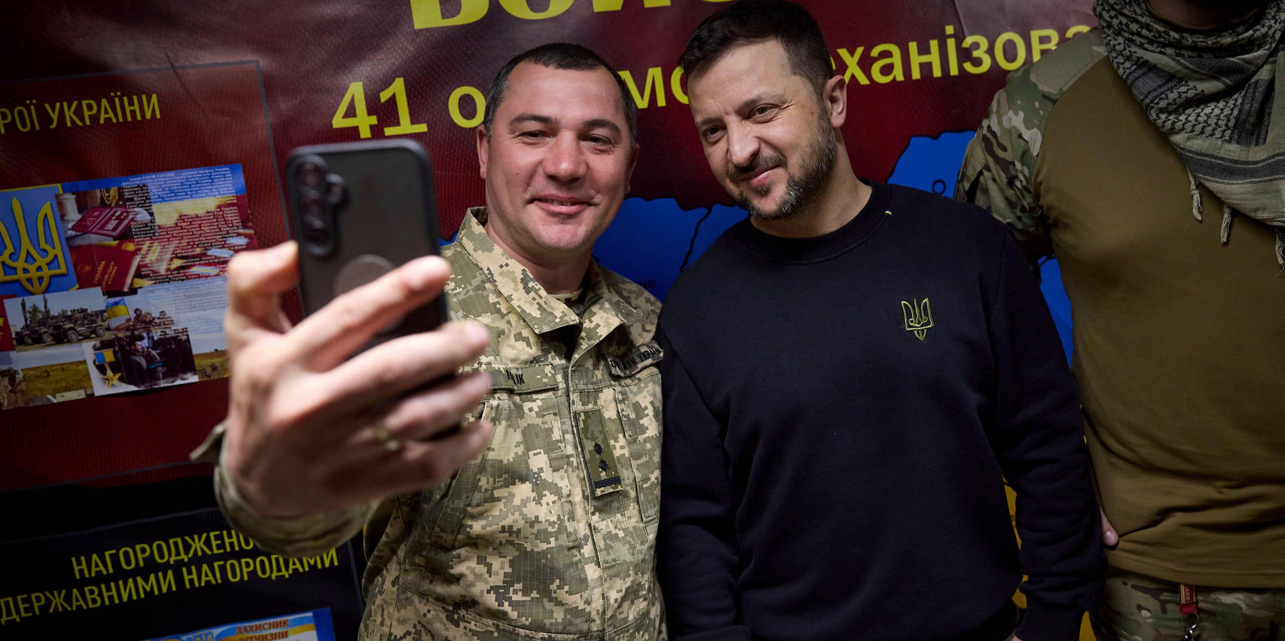 A Ukrainian soldier takes a selfie with VOlodymyr Zelensky, May 2024.