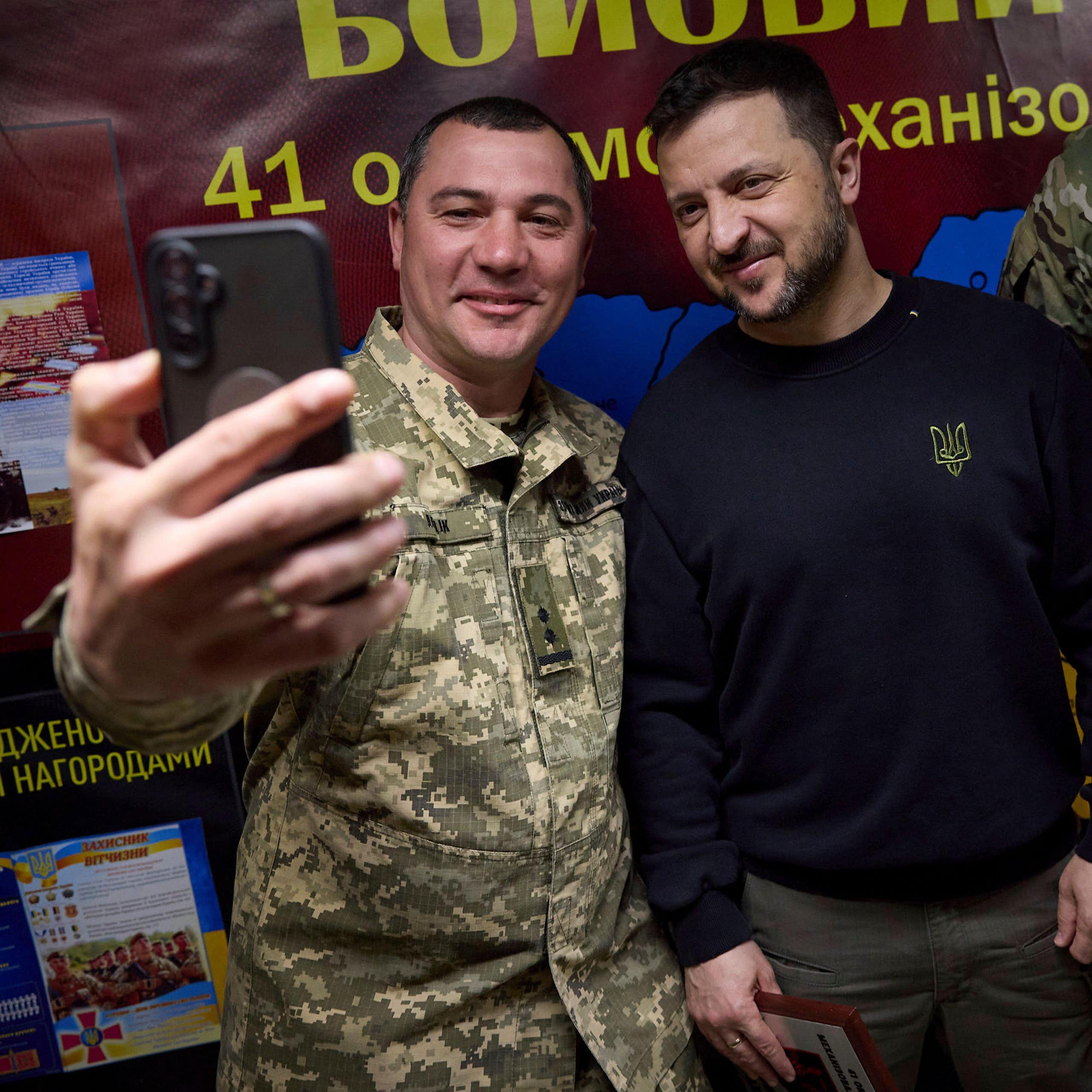A Ukrainian soldier takes a selfie with VOlodymyr Zelensky, May 2024.