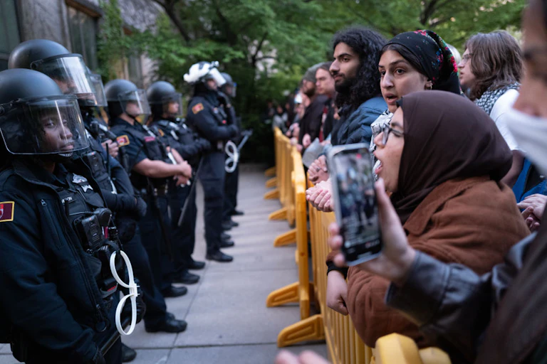 Protesters confront police in riot gear.