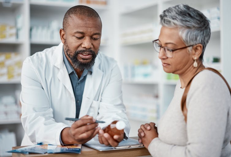 A pharmacist and woman discussing a medication