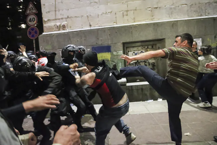 Demonstrators scuffle with riot police.