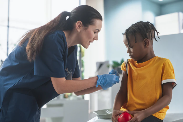 A female health-care worker gives a boy a vaccine.