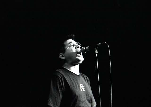 Black and white photo, Albini at a microphone