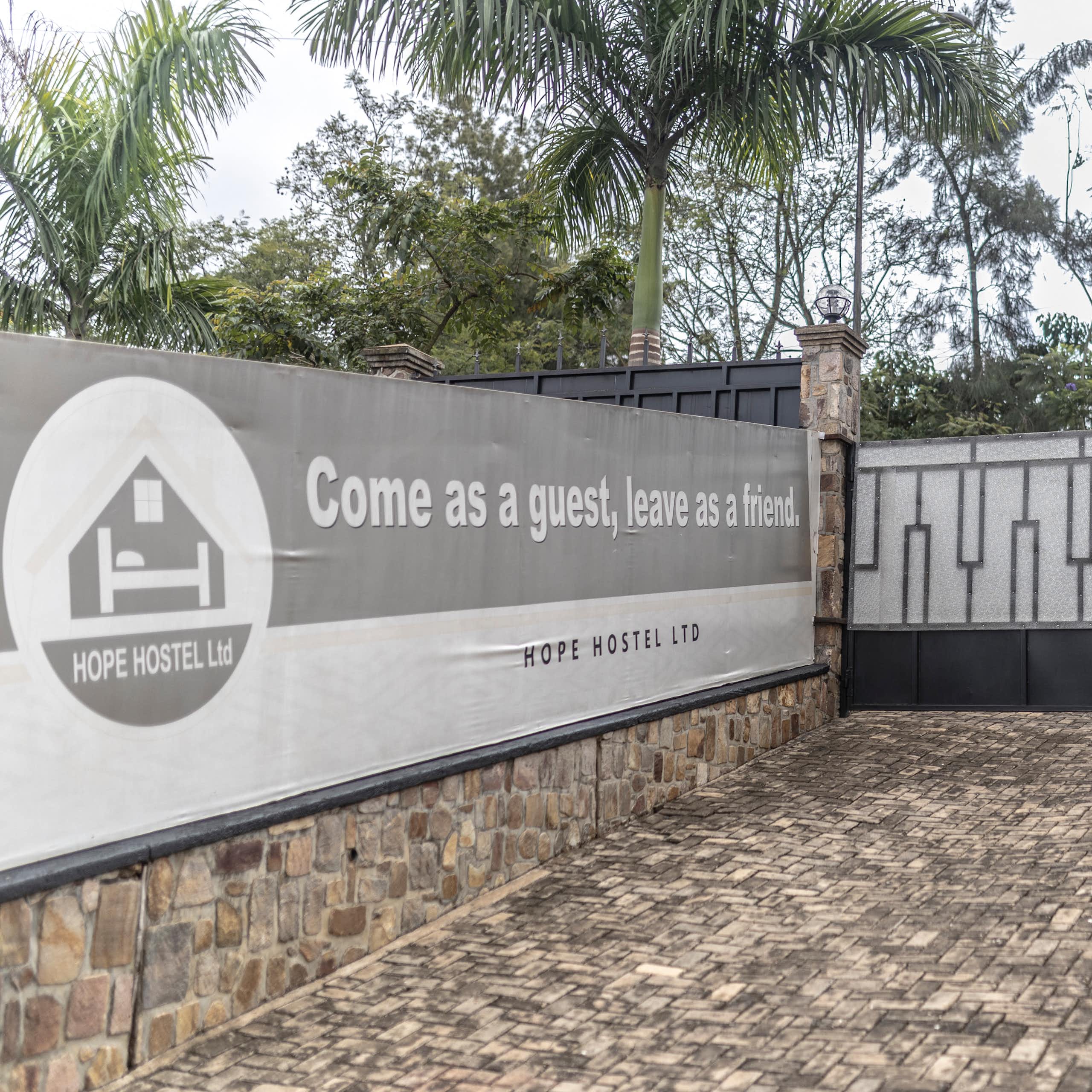 A paved and gated space with a banner on a wall saying Come as a guest, leave as a friend.