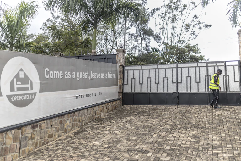 A paved and gated space with a banner on a wall saying Come as a guest, leave as a friend.