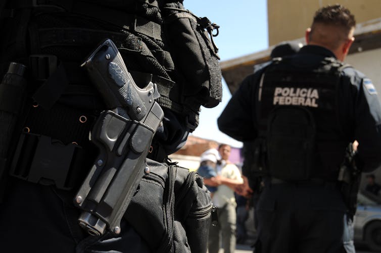 Closeup shot of a handgun around the waist of a Mexican federal policeman.
