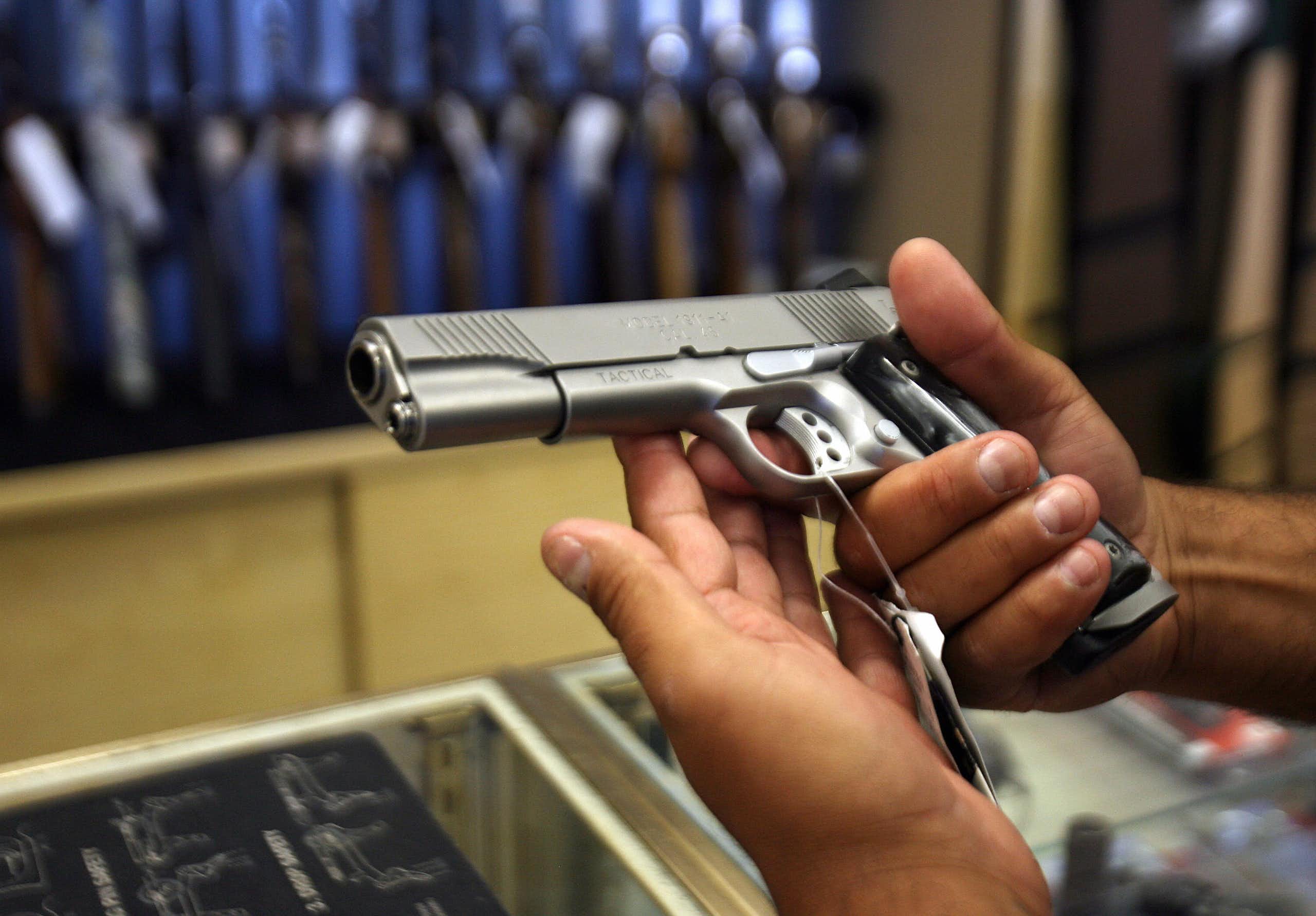 A man examines a handgun in a California gun store.