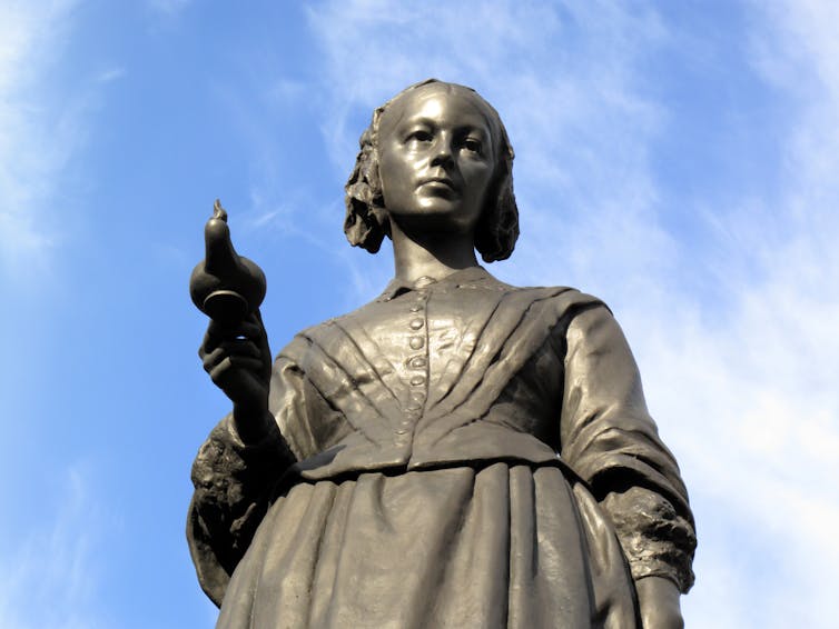 Memorial statue of Florence Nightingale against a blue sky.