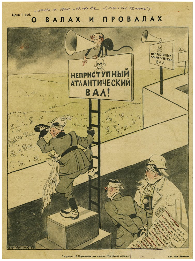 Una caricatura que muestra a funcionarios nazis mirando por encima de un muro, mientras Hitler sostiene una lista de los bastiones nazis caídos.