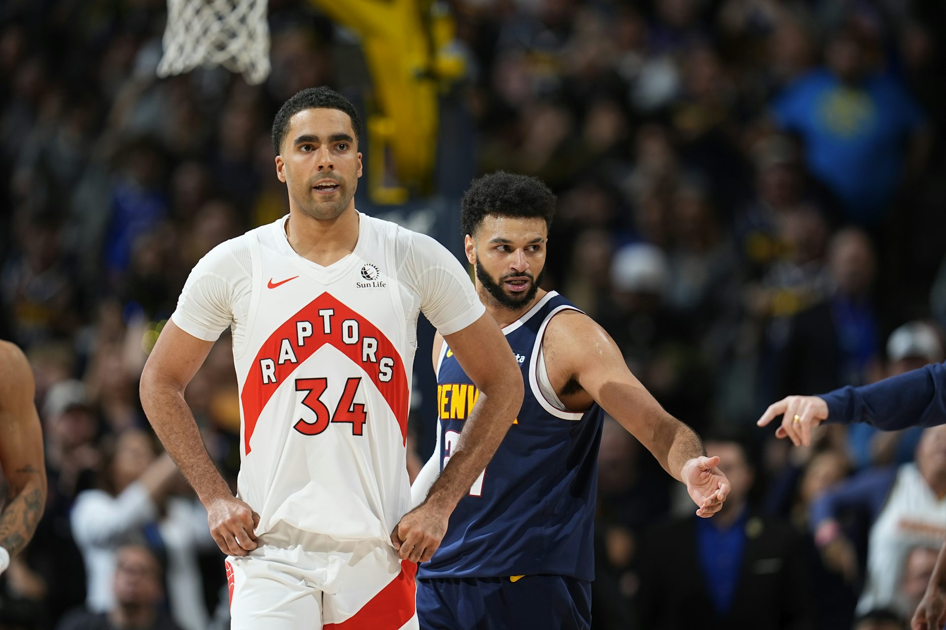 A basketball player in a Toronto Raptors jersey walking down a basketball court