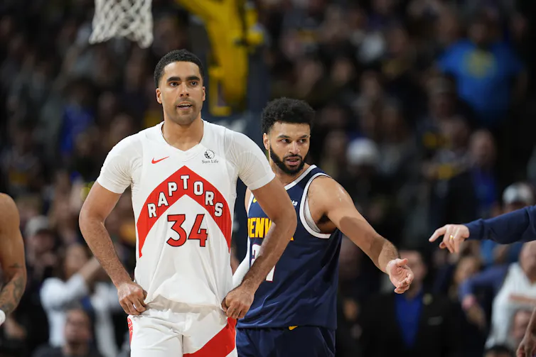 A basketball player in a Toronto Raptors jersey walking down a basketball court